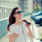 Businesswoman with touchpad watching and listening to information